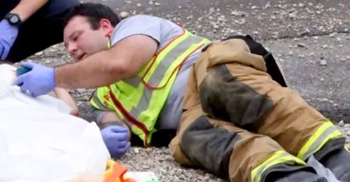 Feuerwehrmann beruhigt ein Kind nach einem Unfall, indem er es mit seinem Handy spielen lässt: das ergreifende Foto