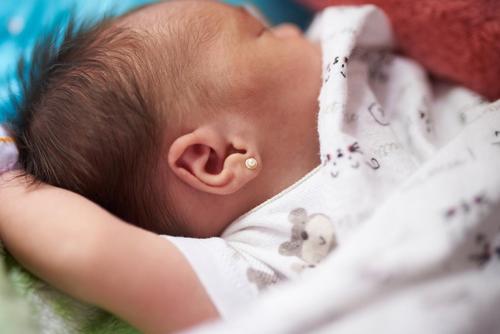 Vater entfernt wütend Ohrringe von den Ohren seines Babys, nachdem seine Frau sie heimlich piercen ließ