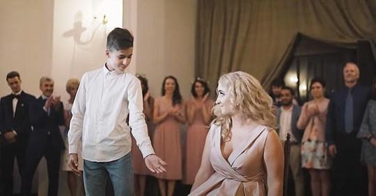 Der kleine Bruder der Braut streckt seine Hand aus, um sie zum Tanz aufzufordern und stiehlt die Show
