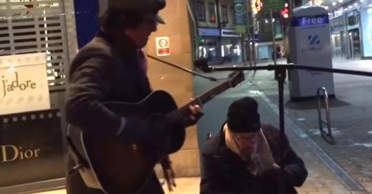 Obdachloser Mann bittet Straßenmusiker mitsingen zu dürfen, sobald er anfängt zu singen bleiben alle Fußgänger stehen und hören zu
