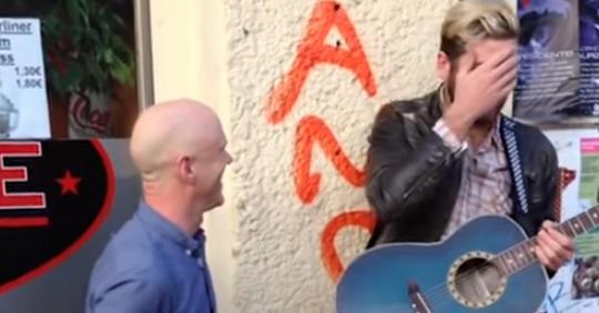 Straßenmusikant spielt Lied auf seiner Gitarre als Original-Sänger nähert sich für ein großartiges Duett